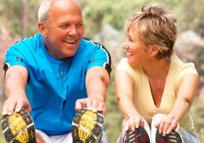 Una pareja de adultos mayores haciendo ejercicio en el parque